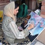 An art student paints her ideas on canvas during a painting competition organized by the Punjab Council of Arts, Faisalabad Division, to mark the Marka-e-Haq and Independence Day celebrations