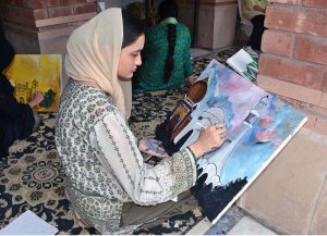 An art student paints her ideas on canvas during a painting competition organized by the Punjab Council of Arts, Faisalabad Division, to mark the Marka-e-Haq and Independence Day celebrations