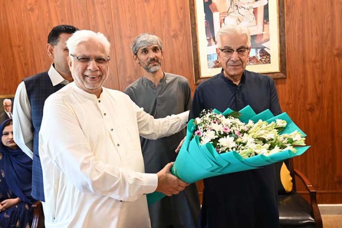 Former President of the Chamber of Commerce, Sheikh Tahir Majeed, congratulates Defense Minister Khawaja Muhammad Asif on receiving the Sitara-e-Imtiaz by presenting him with a bouquet of flowers