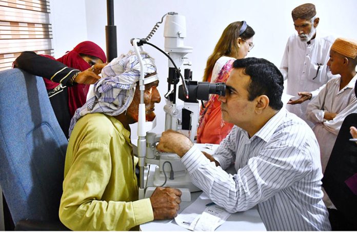 Doctors examining eye patients during free eye camp by LUMHS at health services hospital Jamshoro
