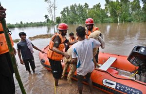 Residents wade through floodwater while evacuating to safer places after Mid Ranjha was inundated, as rivers swelled above dangerous levels due to heavy rains and the opening of Indian floodgates.