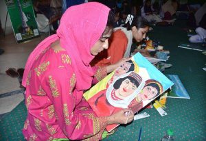 An art student paints her ideas on canvas during a painting competition organized by the Punjab Council of Arts, Faisalabad Division, to mark the Marka-e-Haq and Independence Day celebrations