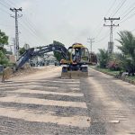 A heavy machinery being used to break road during repairing work of Autobahn Road
