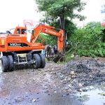 Workers using a heavy machine to clean a blocked sewerage line