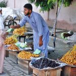 A vendor displays dates to attract customers at a roadside stall in the city.