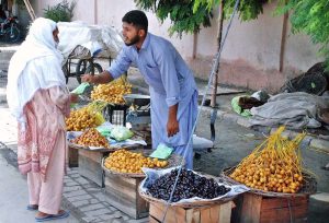 A vendor displays dates to attract customers at a roadside stall in the city.