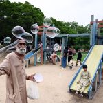 An elderly man sells soap bubbles at Frere Hall