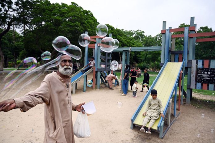 An elderly man sells soap bubbles at Frere Hall