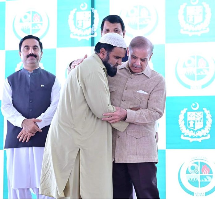 Prime Minister Muhammad Shehbaz Sharif distributing relief cheques among the victims of the recent torrential rains and floods in Buner