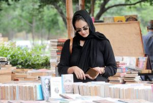 A woman browsing books at a book fair at Frere Hall