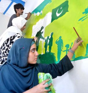 Students paint a wall at Central Jail Hyderabad as part of "Jashan-e-Marka-e-Haq" and Independence Day celebrations ahead of Pakistan’s 78th Independence Day.