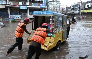 Rescue 1122 personnel areassist citizens as the removing a rickshaw stuck on a flooded road during heavy rains during the ongoing monsoon.
