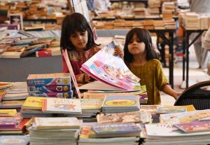 A woman browsing books at a book fair at Frere Hall