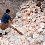Labourers busy breaking salt into small pieces for sale in the market.