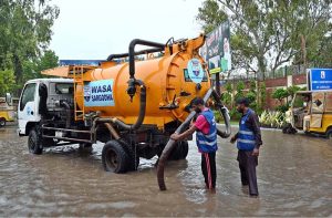 Rescue 1122 personnel areassist citizens as the removing a rickshaw stuck on a flooded road during heavy rains during the ongoing monsoon.