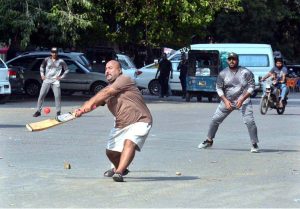 Youngsters playing cricket on a road in the Saddar area during the holiday.