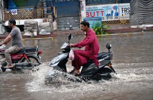 Rescue 1122 personnel areassist citizens as the removing a rickshaw stuck on a flooded road during heavy rains during the ongoing monsoon.