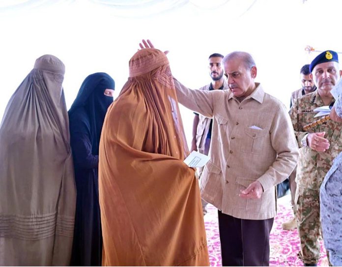 Prime Minister Muhammad Shehbaz Sharif distributing relief cheques among the victims of the recent torrential rains and floods in Buner