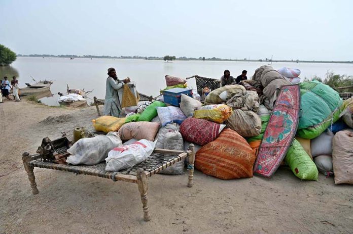 Flood-affected residents of Nizam Kalhoro village in the Kachha area of the Indus River shift their belongings to safer places after the district administration issued a flood warning