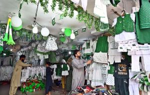A vendor displays children’s outfits printed with national flags at his shop on Katchery Road to attract customers ahead of the upcoming Independence Day.