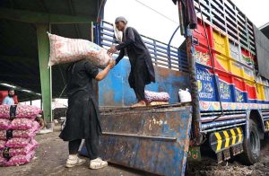 - Laborers busy in loading garlic sacks in a delivery truck at Vegetable Market.