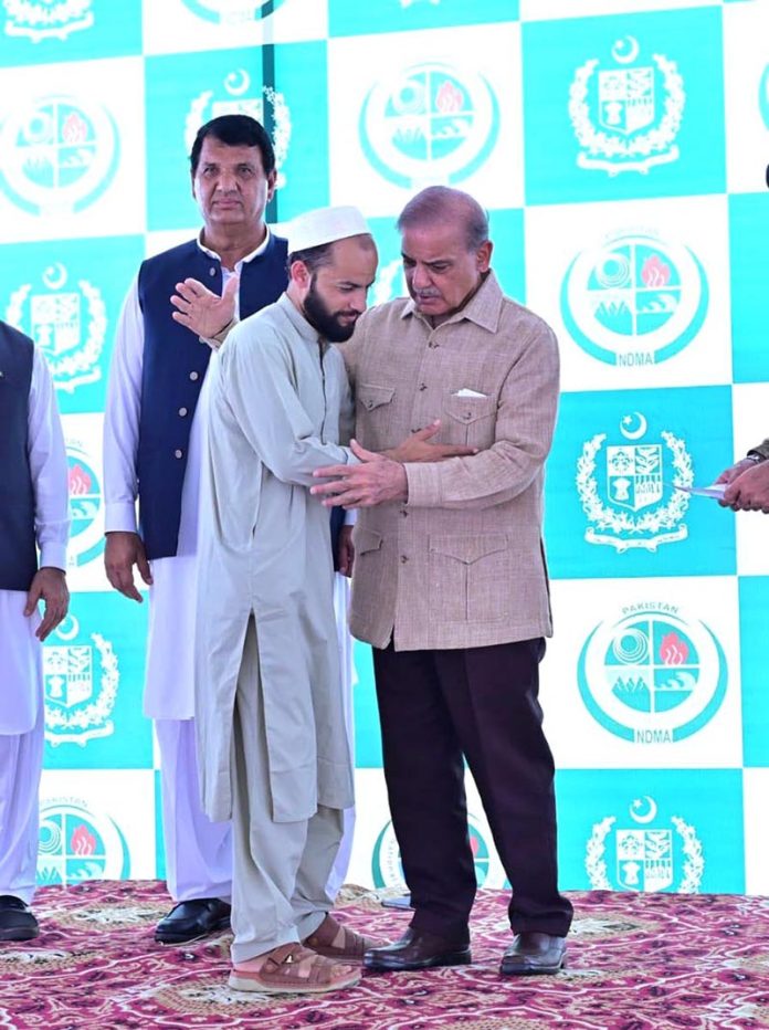 Prime Minister Muhammad Shehbaz Sharif distributing relief cheques among the victims of the recent torrential rains and floods in Buner