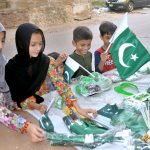 Children selecting national flags and badges from a stall in connection with celebration of 78th Independence Day with the theme of Maarka-E-Haq at Latifabad