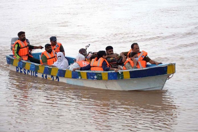 Rescue 1122 team evacuates flood-affected people to safer places by boat during a relief operation