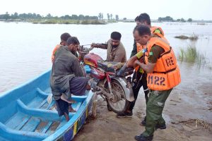 Rescue 1122 team evacuates flood-affected people to safer places by boat during a relief operation