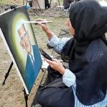 An art student gives final touches to her portrait during an art competition as the nation prepares to celebrate 78th Independence Day