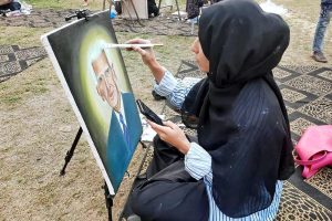 An art student gives final touches to her portrait during an art competition as the nation prepares to celebrate 78th Independence Day