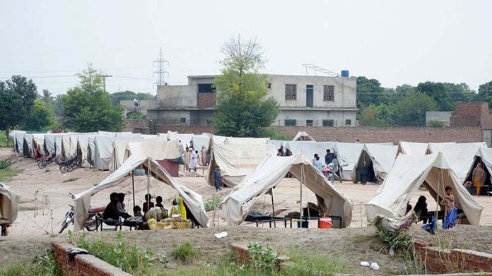 A volunteer distributing lunch among the flood-affected people at a temporary relief camp