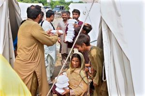 A volunteer distributing lunch among the flood-affected people at a temporary relief camp