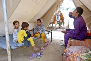 A volunteer distributing lunch among the flood-affected people at a temporary relief camp