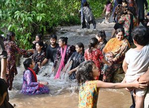A large number of people enjoy wading through the cool water of a stream in the Margalla Hills trail 5 to escape the intense heat in the Federal Capital