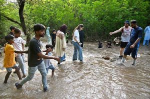 A large number of people enjoy wading through the cool water of a stream in the Margalla Hills trail 5 to escape the intense heat in the Federal Capital