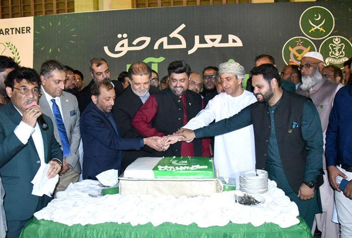 Sindh Governor Kamran Khan Tessori, along with foreign consul generals and others, cuts a cake during a ceremony held at the Governor House to mark Marka-e-Haq and Independence Day celebrations