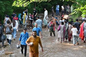 A large number of people enjoy wading through the cool water of a stream in the Margalla Hills trail 5 to escape the intense heat in the Federal Capital