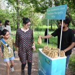 A volunteer distributes seed balls to visitors during the 'Seed Ball Distribution Campaign' organized by Pakistan Tobacco Company (PTC) in collaboration with the Capital Development Authority (CDA) at Trail 5 entrance, encouraging efforts to green the Margalla Hills