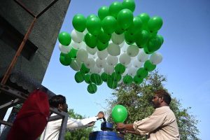 A man purchases balloons in the colors of Pakistan's national flag from a roadside vendor in the federal capital to commemorate the country's 78th Independence Day, 'Maarka e Haq'