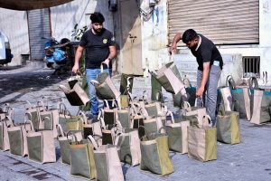 Vendors display traditional handmade bags at a roadside to attract customers