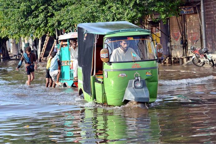 Vehicles passing through accumulated water at Makkah Road after rain in the Provincial Capital