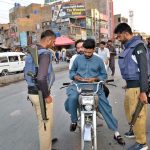 Police personnel checking motorcyclists’ IDs and licences at Meezan Chowk as the provincial government enforces Section 144 on motorcycle riding ahead of Independence Day