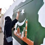 A female student painting a national flag on wall to mark the Independence Day celebrations in Quetta