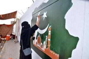 A female student painting a national flag on wall to mark the Independence Day celebrations in Quetta