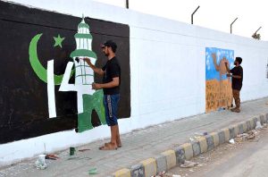 A female student painting a national flag on wall to mark the Independence Day celebrations in Quetta