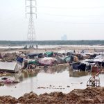 Shanties of gypsies near the road to Korangi submerged in water due to heavy downpour experienced in the city
