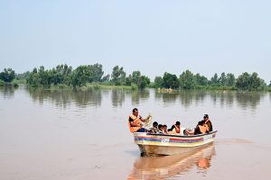 Rescue personnel helps to evacuate a family from the flooded area at Mandi Faizabad district Nankana