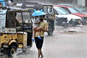 A girl rides her scooty through the rain-soaked streets of the city during a monsoon downpour