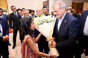 A child greets the visiting Iranian President, Dr Masoud Pezeshkian, with a bouquet in Awan-e- Sadr